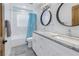 Bright bathroom featuring dual sinks, granite countertops, and stylish round mirrors at 533 Lillian Dr, Madeira Beach, FL 33708