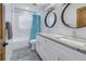 Bright bathroom featuring dual sinks, granite countertops, and stylish round mirrors at 533 Lillian Dr, Madeira Beach, FL 33708