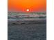 A breathtaking sunset over a serene beach, with gentle waves rolling onto the sandy shore at 533 Lillian Dr, Madeira Beach, FL 33708