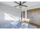 Bedroom features wood floors, ceiling fan and closet with rustic doors at 533 Lillian Dr, Madeira Beach, FL 33708