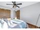 Bedroom featuring a ceiling fan, natural wood doors, and comfortable bedding at 533 Lillian Dr, Madeira Beach, FL 33708