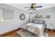 Bright bedroom features a ceiling fan, a comfortable bed, and a decorative round mirror on the wall at 533 Lillian Dr, Madeira Beach, FL 33708