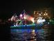 A decorated boat illuminated with colorful lights cruises on the water during a festive holiday parade at 533 Lillian Dr, Madeira Beach, FL 33708
