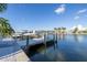 Waterfront property showcasing a private boat dock with serene water views and lush landscaping at 533 Lillian Dr, Madeira Beach, FL 33708
