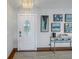 Inviting entryway with decorative glass door, stylish artwork, console table, and travertine tile flooring at 533 Lillian Dr, Madeira Beach, FL 33708