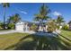 Charming single-story home with a well-manicured lawn and lush tropical landscaping in a waterfront community at 533 Lillian Dr, Madeira Beach, FL 33708