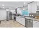 A modern kitchen featuring stainless steel appliances, light granite countertops, and updated cabinetry at 533 Lillian Dr, Madeira Beach, FL 33708