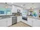 Bright kitchen features white cabinets, stainless steel appliances, and granite countertops at 533 Lillian Dr, Madeira Beach, FL 33708