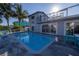 This backyard features a pool, patio, lounge seating, and a partial view of the house with sliding glass doors at 533 Lillian Dr, Madeira Beach, FL 33708