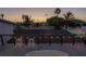 A rooftop view shows barstool seating, an iron railing, and string lights over neighborhood homes at dusk at 533 Lillian Dr, Madeira Beach, FL 33708