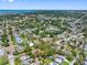 Wide aerial view showcases neighborhood with lush trees and coastal skyline in the distance at 568 La Plaza S Ave, St Petersburg, FL 33707