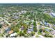 Extensive aerial view captures neighborhood with lush trees and a distant cityscape at 568 La Plaza S Ave, St Petersburg, FL 33707