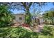 View of the backyard with a charming outdoor space with mature trees, lush greenery, and a stone pathway at 568 La Plaza S Ave, St Petersburg, FL 33707
