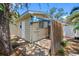 Exterior backyard view with a small covered area, door access, and side yard space surrounded by lush greenery and a fence at 568 La Plaza S Ave, St Petersburg, FL 33707