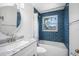 Bathroom features updated vanity, mirror, and blue tiled tub with shower combo at 568 La Plaza S Ave, St Petersburg, FL 33707