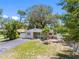 Charming single-story home with a paved driveway, manicured landscaping, and inviting outdoor seating area at 568 La Plaza S Ave, St Petersburg, FL 33707