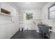 Spacious laundry room featuring built-in shelving, a utility sink, and updated flooring at 568 La Plaza S Ave, St Petersburg, FL 33707