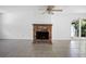 Inviting living room featuring tile flooring, a vintage brick fireplace, and sliding glass doors to the outdoors at 568 La Plaza S Ave, St Petersburg, FL 33707