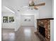 Bright living room featuring tile flooring, a rustic brick fireplace, and a modern ceiling fan at 568 La Plaza S Ave, St Petersburg, FL 33707