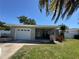 Charming single-story home with a well-manicured lawn, attached garage, and beautiful curb appeal at 5800 Dartmouth N Ave, St Petersburg, FL 33710