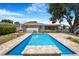 Backyard featuring a pristine swimming pool, brick patio, and serene landscaping at 5800 Dartmouth N Ave, St Petersburg, FL 33710