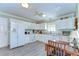 Bright kitchen featuring white appliances, white cabinets, and laminate wood flooring at 5906 Greenbriar Ct, Zephyrhills, FL 33542