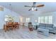 Open-concept living area with wood laminate floors and bright natural light at 5906 Greenbriar Ct, Zephyrhills, FL 33542