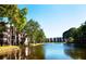 Scenic waterfront condo complex view with lush landscaping and a tranquil lake, under a bright blue sky at 5980 80Th St N # 106, St Petersburg, FL 33709