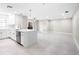 Bright, open-concept living area with sleek white kitchen, quartz island, and tile flooring at 5980 80Th St N # 106, St Petersburg, FL 33709