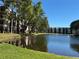 Scenic view of the community pond surrounded by lush landscaping and multi-story condo buildings on a sunny day at 5980 80Th St N # 106, St Petersburg, FL 33709