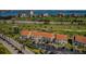 Scenic aerial view of condos with a red-tiled roof, surrounded by a golf course and blue waters in the background at 6191 Bahia Del Mar Blvd # 103, St Petersburg, FL 33715