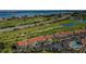 Expansive aerial showcasing golf course condos with a red-tiled roof and a swimming pool in a waterfront community at 6191 Bahia Del Mar Blvd # 103, St Petersburg, FL 33715