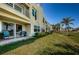 Relaxing backyard with a patio featuring seating, green grass, and a view of palm trees at 6191 Bahia Del Mar Blvd # 103, St Petersburg, FL 33715