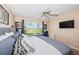 Bright bedroom with scenic view from the window, ceiling fan, and an adjoining work space at 6191 Bahia Del Mar Blvd # 103, St Petersburg, FL 33715