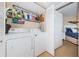 Bright laundry room with full-size washer and dryer, and shelving for storage at 6191 Bahia Del Mar Blvd # 103, St Petersburg, FL 33715