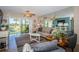 Bright living room with a view of the golf course with a ceiling fan and sliding glass doors to the patio at 6191 Bahia Del Mar Blvd # 103, St Petersburg, FL 33715