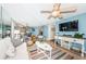 Open living area with blue accent wall, fan, and a view of the dining area and kitchen at 6191 Bahia Del Mar Blvd # 103, St Petersburg, FL 33715