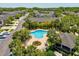Aerial view of a kidney shaped pool with lounge seating, community buildings, and lush landscaping in a residential community at 6910 Rock Springs Way, Tampa, FL 33625