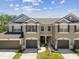 Charming townhome with attached garage and landscaped front yard, offering a welcoming curb appeal under a sunny sky at 6910 Rock Springs Way, Tampa, FL 33625