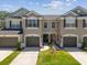 Townhome showcases a manicured lawn, garage doors, and well-maintained landscaping at 6910 Rock Springs Way, Tampa, FL 33625