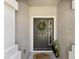 Close-up of a charming front door with a welcoming wreath, sidelight window, and stylish welcome mat at 6910 Rock Springs Way, Tampa, FL 33625