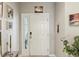 Inviting entryway featuring a white front door with sidelight window, complemented by stylish decor and plants at 6910 Rock Springs Way, Tampa, FL 33625