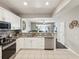 Modern kitchen with white cabinets, granite countertops, stainless steel appliances, and an open view to the living area at 6910 Rock Springs Way, Tampa, FL 33625
