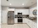 Well-lit kitchen featuring white cabinets, stainless steel appliances, granite counters, and tiled backsplash at 6910 Rock Springs Way, Tampa, FL 33625