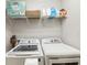 Functional laundry room with modern washer and dryer, plus shelving for storage at 6910 Rock Springs Way, Tampa, FL 33625