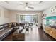 Cozy living room featuring a plush sofa, dark wood floors, and sliding doors leading to a screened patio at 6910 Rock Springs Way, Tampa, FL 33625
