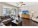Stylish living room with sliding glass doors to the patio, dark wood floors, and a modern entertainment center at 6910 Rock Springs Way, Tampa, FL 33625