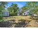 Expansive backyard showcasing lush greenery, multiple storage sheds, and a charming home at 7309 N Huntley Ave, Tampa, FL 33604