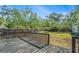Large backyard featuring a wooden deck, mature trees, and a well-maintained lawn at 7309 N Huntley Ave, Tampa, FL 33604