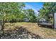 Fenced backyard with lush trees, a wooden deck, and storage shed for added convenience at 7309 N Huntley Ave, Tampa, FL 33604
